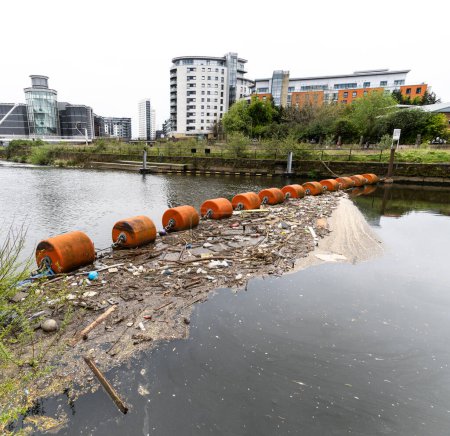 Téléchargez les photos : Une chaîne flottante à flèche suspendue à travers l'Aire de la rivière à Leeds Dock à Leeds pour protéger les bateaux du déversoir et la collecte des débris et des déchets dans un concept de problème environnemental - en image libre de droit