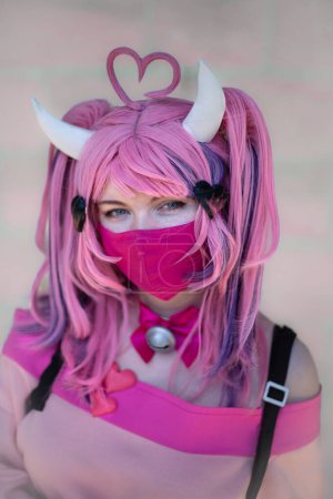 Foto de Una chica bonita cosplayer vistiendo un traje de anime japonés con pelo rosa y mascarilla en un evento cómico con el Reino Unido - Imagen libre de derechos