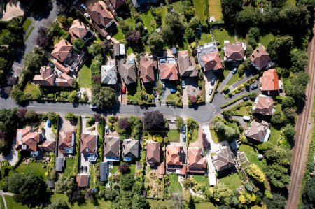 Téléchargez les photos : Carte aérienne de style paysage de maisons individuelles de banlieue avec des allées et des jardins sur un développement résidentiel exclusif dans un petit environnement de village - en image libre de droit