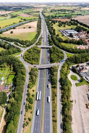Foto de Panorama vertical aéreo directamente encima de una concurrida intersección de carreteras que atraviesa el campo en la autopista M62 hacia el este en dirección a Hull en el Reino Unido - Imagen libre de derechos
