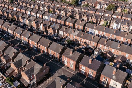 Photo for An aerial view above the drab rooftops of run down back to back terraced houses on a large residential estate in the North of England - Royalty Free Image