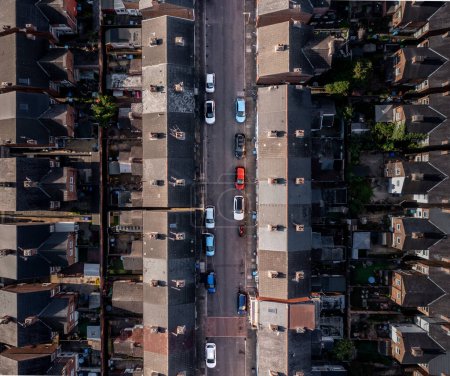 Téléchargez les photos : Une vue aérienne directement au-dessus d'une rue avec des voitures garées et les toits de courir dos à dos maisons mitoyennes sur un grand domaine résidentiel dans le nord de l'Angleterre - en image libre de droit