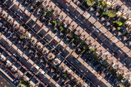 Téléchargez les photos : Une vue aérienne directement au-dessus des toits de maisons mitoyennes sur un grand domaine résidentiel dans le nord de l'Angleterre avec des rues et des cours arrière - en image libre de droit