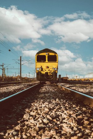 Foto de Punto de vista de ángulo bajo de una locomotora ferroviaria de mercancías que se aproxima por vías férreas y traviesas con espacio para copias - Imagen libre de derechos