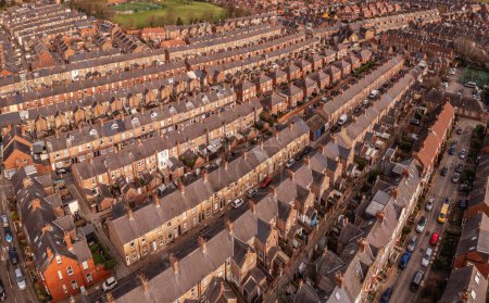 Téléchargez les photos : Une vue aérienne au-dessus des toits de maisons mitoyennes dos à dos sur un grand domaine résidentiel dans le nord de l'Angleterre - en image libre de droit