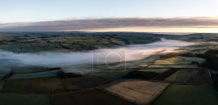 Luftaufnahme des tief liegenden Nebels oder der Wolkenumkehrung entlang des Tals des Flusses Tyne an der Haydon Bridge in der Nähe von Hexham an einem kalten Wintermorgen
