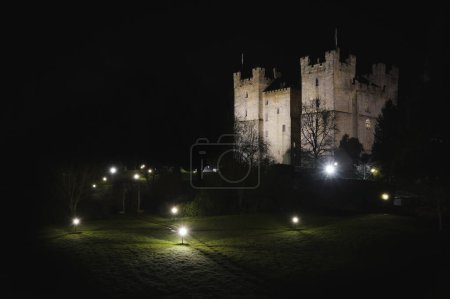 Téléchargez les photos : LANGLEY CASTLE, NORTHUMBERLAND, RU - 16 MARS 2024. Vue panoramique du paysage de l'architecture historique et médiévale du château de Langley et du jardin dans le parc national Northumberland illuminé la nuit - en image libre de droit