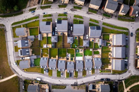 Luftaufnahme von oben über einem Block neu gebauter Vorstadthäuser in Großbritannien mit kleinen Gärten