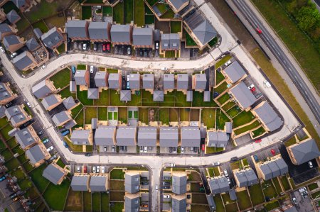 Aerial top down view above a block of newly built suburban homes in the UK with small gardens