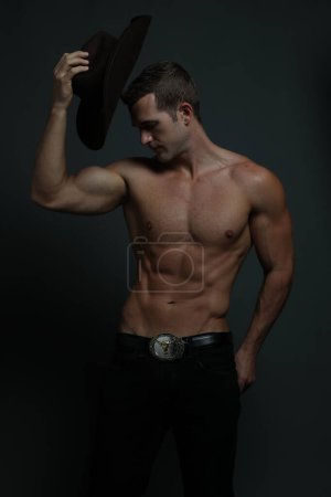 Handsome Shirtless Cowboy Posing against gray background