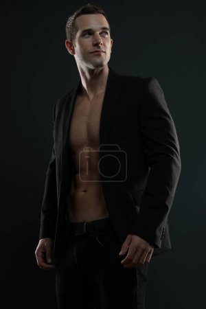 Hombre en una chaqueta de traje sin camisa con 6 abdominales paquete