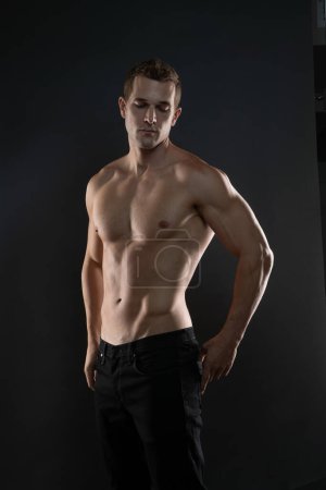 Foto de Modelo de moda con las manos en la cadera mostrando los músculos sin camisa - Imagen libre de derechos