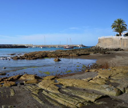 Téléchargez les photos : Plage à marée basse au premier plan, port en arrière-plan et ciel bleu, côte d'Arguineguin, Grande Canarie, Îles Canaries - en image libre de droit