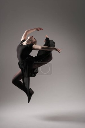 Foto de Bailarina bailando con tela de seda, bailarina de ballet moderna en tela ondulante, fondo gris. - Imagen libre de derechos