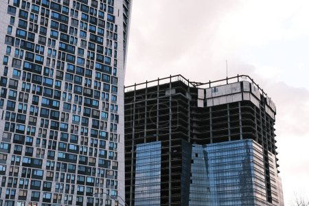 Foto de Vista de ángulo bajo del edificio de oficinas moderno por obra contra el cielo en la ciudad. - Imagen libre de derechos