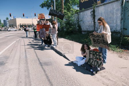 Téléchargez les photos : Kiev, Ukraine - 28 avril 2024. Des bébés manifestants ukrainiens agitent fièrement les drapeaux et les bannières de la brigade Azov en lisant Libérez Azov, illustrant l'unité et l'activisme pour la libération des prisonniers de guerre. - en image libre de droit