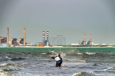 Téléchargez les photos : Un pêcheur jette ses filets dans la mer - en image libre de droit