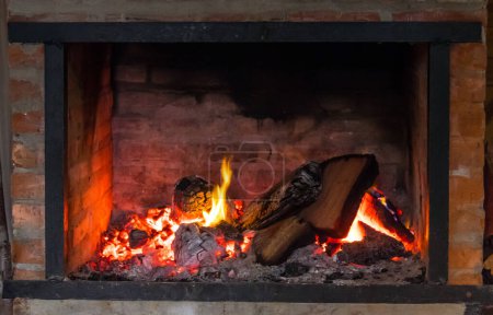 Photo for Cozy Fireplace with Bright Burning Flames and Textured Logs - Royalty Free Image