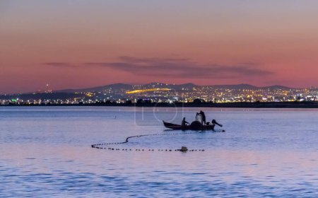 Téléchargez les photos : Pêcheur en petit bateau au coucher du soleil en Tunisie, Afrique du Nord - en image libre de droit