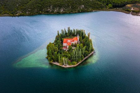 Foto de Visovac, Croacia - Vista aérea de la hermosa isla Monasterio cristiano de Visovac en el Parque Nacional Krka en una brillante mañana de verano - Imagen libre de derechos