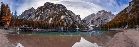Lake Braies, Italy - Panoramic view of autumn morning at Lake Braies (Lago di Braies) in Italian Dolomites at South Tyrol with wooden boats, wooden cabin blue sky and Seekofel Mountain at background