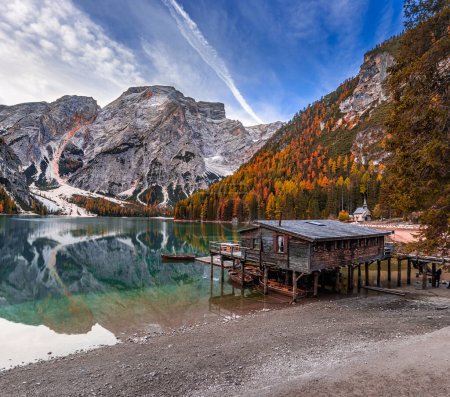 Téléchargez les photos : Lac de Braies, Italie Belle matinée d'automne au lac de Braies (Lago di Braies) dans les Dolomites italiennes au Tyrol du Sud avec des bateaux en bois, cabine en bois ciel bleu et Seekofel Mountain reflétant dans le lac - en image libre de droit