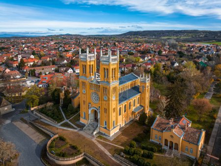 Photo for Fot, Hungary - Aerial view of the Roman Catholic Church of the Immaculate Conception (Szeplotlen Fogantatas templom) in the town of Fot on a sunny spring day with blue sky and clouds - Royalty Free Image