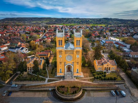 Photo for Fot, Hungary - Aerial view of the Roman Catholic Church of the Immaculate Conception (Szeplotlen Fogantatas templom) in the town of Fot on a sunny spring day with blue sky and clouds - Royalty Free Image