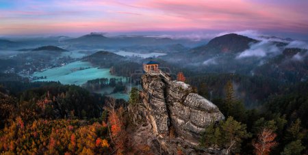 Foto de Jetrichovice, Czech Republic - Aerial panoramic view of Mariina Vyhlidka (Mary's view) lookout with foggy Czech autumn landscape and colorful pink sunrise sky in Bohemian Switzerland National Park - Imagen libre de derechos