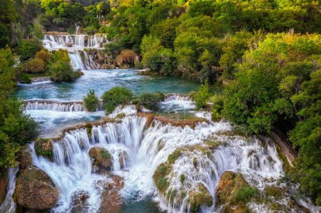 Téléchargez les photos : Krka, Croatie - Vue aérienne de la belle cascade de Krka dans le parc national de Krka par un matin d'été lumineux avec un feuillage vert et de l'eau turquoise - en image libre de droit