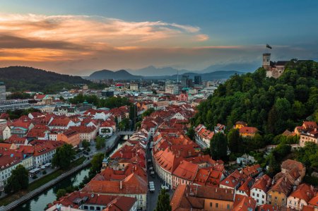 Téléchargez les photos : Ljubljana, Slovénie - Vue aérienne de Ljubljana par un après-midi d "été avec l" église franciscaine de l'Annonciation, le château de Ljubljana, la cathédrale de Ljubljana et les toits de la capitale slovène au ciel doré couchant - en image libre de droit