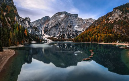 Foto de Lago Braies, Italia - Vista panorámica aérea del Lago Braies (Lago di Braies) en los Dolomitas italianos en el Tirol del Sur con cielo azul, barcos de madera y la montaña Seekofel reflejándose en el lago en la mañana de otoño - Imagen libre de derechos
