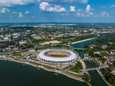 Foto de Budapest, Hungría - Vista aérea de la nueva arena deportiva del Centro Nacional de Atletismo en la orilla del río de Budapest en un día soleado de verano con cielo azul y nubes - Imagen libre de derechos
