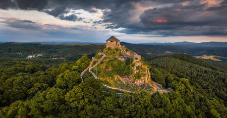 Photo for Salgotarjan, Hungary - Aerial panoramic view of Salgo Castle (Salgo vara) in Nograd county with dark clouds above at sunset on a sunny summer afternoon - Royalty Free Image