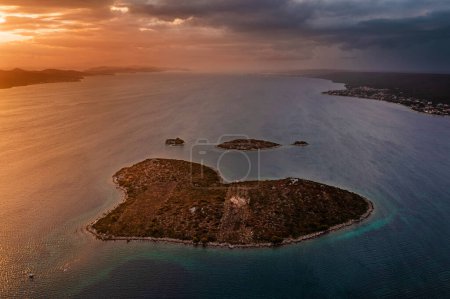 Téléchargez les photos : Galesnjak, Croatie - Vue panoramique aérienne de la belle île en forme de cœur Galesnjak avec un coucher de soleil chaud et coloré en été au-dessus de la mer Adriatique méditerranée - en image libre de droit