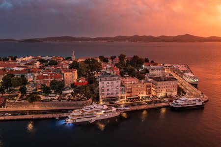 Foto de Zadar, Croacia - Vista aérea del casco antiguo de Zadar al atardecer con yates de amarre, Catedral de Santa Anastasia y un espectacular atardecer dorado de verano al fondo - Imagen libre de derechos
