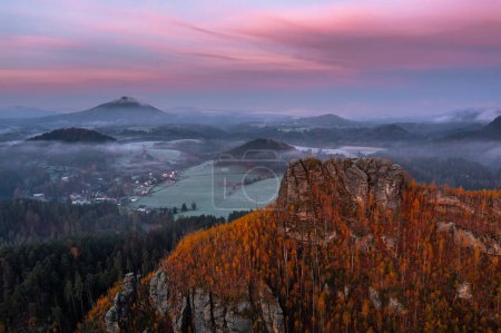 Téléchargez les photos : Jetrichovice, République tchèque - Vue panoramique aérienne du parc national de la Suisse bohème formations rocheuses magnifiques avec montagnes, paysage d'automne brumeux et ciel rose spectaculaire coloré au lever du soleil - en image libre de droit