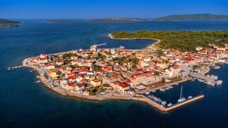 Krapanj, Kroatien - Luftaufnahme der Insel Krapanj (Otok Krapanj), der kleinsten bewohnten Insel in Kroatien. Yachten, rote Dächer und strahlend blauer Himmel an einem sonnigen Sommermorgen an der Adria