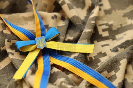 Verpixelter digitaler militärischer Tarnstoff mit ukrainischer Flagge und Wappen auf Streifen in den Farben blau und gelb. Attribute der ukrainischen Soldatenuniform