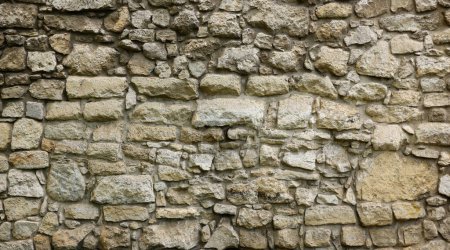 Téléchargez les photos : Texture d'un mur de pierre avec de nombreuses grosses pierres brunes et grises armées de ciment. Vieux château mur de pierre texture arrière-plan pour une utilisation médiévale. Partie d'un bâtiment pierreux comme fond - en image libre de droit