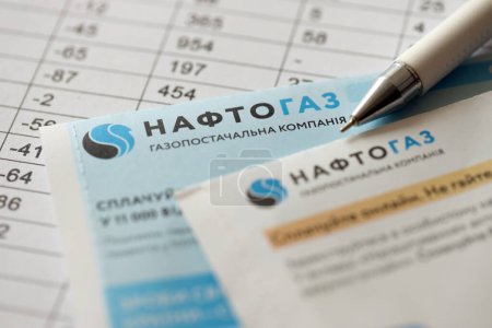 Téléchargez les photos : KYIV, UKRAINE - 7 JUILLET 2023 : Projet de loi sur les services publics de Naftogaz avec de l'argent ukrainien hryvnias sur la table - en image libre de droit
