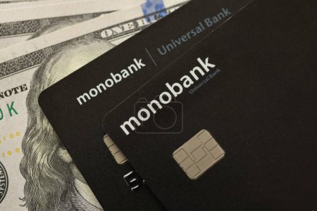 Téléchargez les photos : KYIV, UKRAINE - 7 JUILLET 2023 : Monobank black banking cartes plastiques avec de l'argent sur la table - en image libre de droit