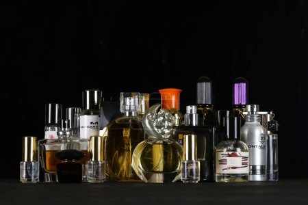 Foto de KHARKIV, UCRANIA - 2 DE ENERO DE 2021 Muchas botellas de perfume de fragancia de varias marcas famosas de fabricantes de perfumes sobre fondo negro oscuro - Imagen libre de derechos