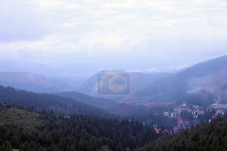 Photo for Morning view of residental area and houses around the Dragobrat mountain peaks in Carpathian mountains, Ukraine. Cloudy and foggy landscape around Drahobrat Peaks in early morning - Royalty Free Image