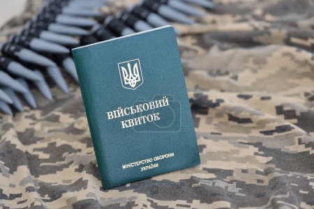 Téléchargez les photos : ID militaire ukrainien sur tissu avec texture de camouflage pixellisé. Tissu avec motif camouflage en forme de pixel gris, brun et vert avec jeton personnel de l'armée ukrainienne et ceinture de mitrailleuse de balles - en image libre de droit