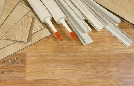 Photo for Set of items for PVC ceiling indoor works. Assembly adhesive bottles and PVC panels with plastic corners. Indoor VPC siding kit. Interior renovation works or construction materials - Royalty Free Image