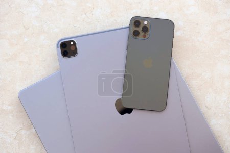 Foto de KYIV, UCRANIA - 4 MAYO 2023: dispositivos de la marca Apple iPhone y el iPad se encuentra en el cuerpo del macbook de cerca - Imagen libre de derechos