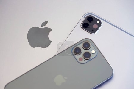 Foto de KYIV, UCRANIA - 4 MAYO 2023: dispositivos de la marca Apple iPhone y el iPad se encuentra en el cuerpo del macbook de cerca - Imagen libre de derechos