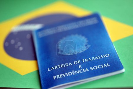 Photo for Brazilian work card and social security blue book on flag of Federative Republic of Brazil close up - Royalty Free Image
