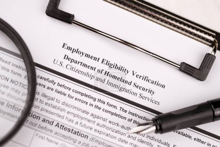 Photo for I-9 Employment Eligibility Verification blank form on A4 tablet lies on office table with pen and magnifying glass close up - Royalty Free Image